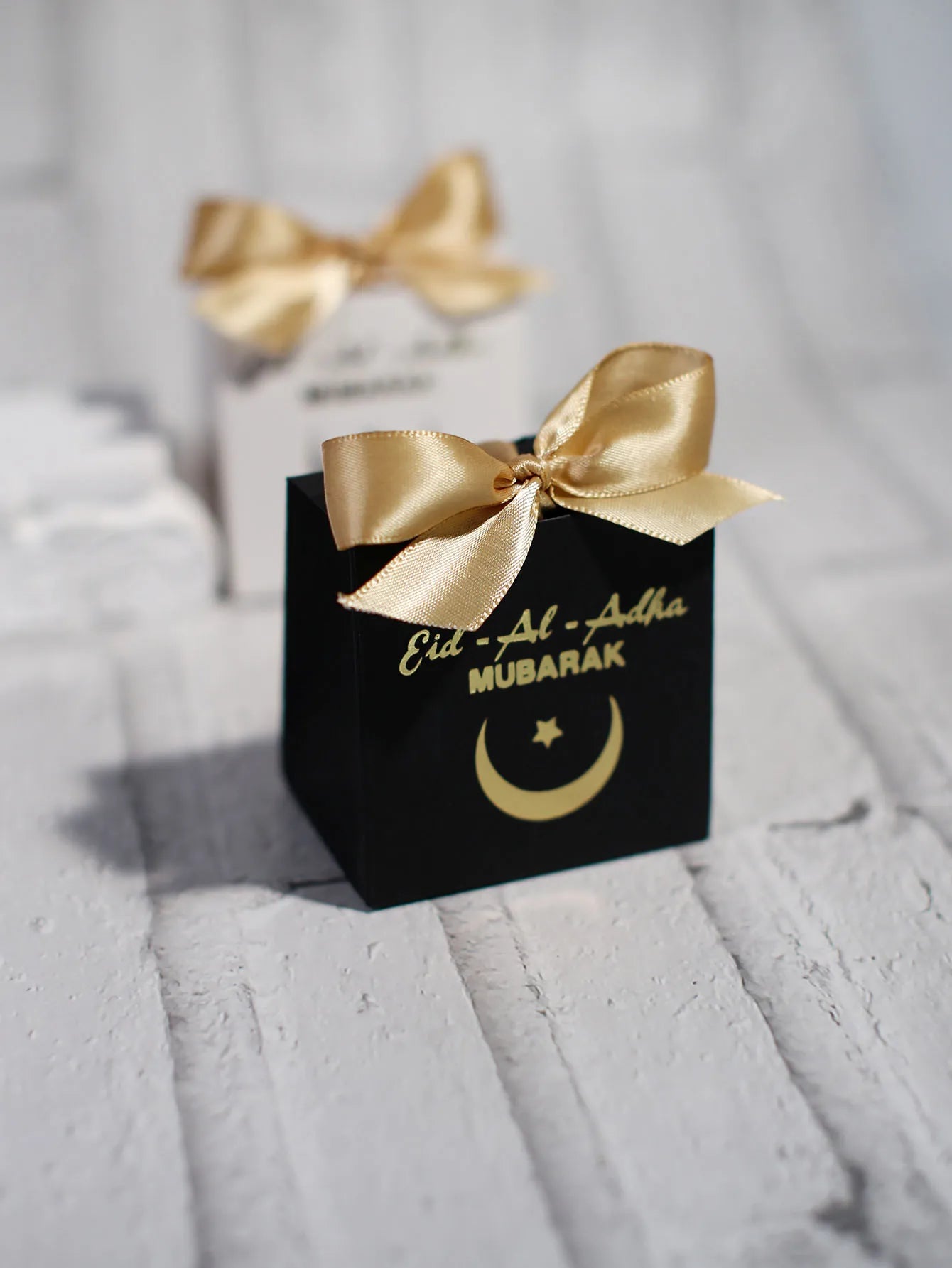 Eid al Adha Gift Box with Golden Ribbon, featuring crescent and star patterns, perfect for gifting to friends and family