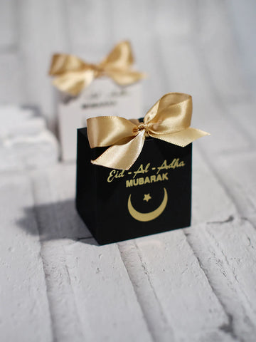 Eid al Adha Gift Box with Golden Ribbon, featuring crescent and star patterns, perfect for gifting to friends and family